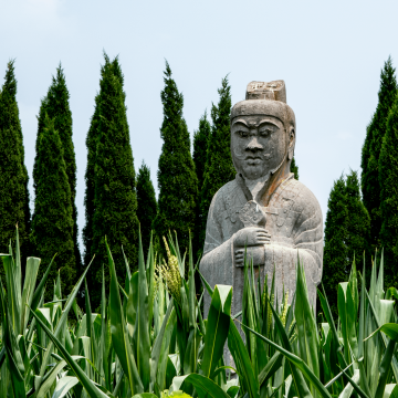 Photo Of A Statue of Buddha Standing In A Forest