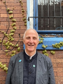 Photo Of Victor Mair Standing In Front Of A Brick Wall