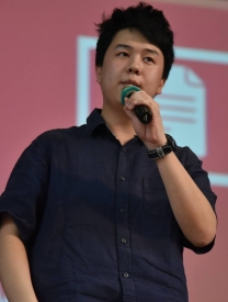 Photo Of Qiu Jun Zheng Standing On Stage With A Microphone