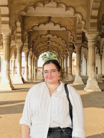 Picture of Sophie from the waist up standing on a veranda