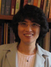 Headshot Of Dr. Maiheng Dietrich Standing In Front Of A Bookcase